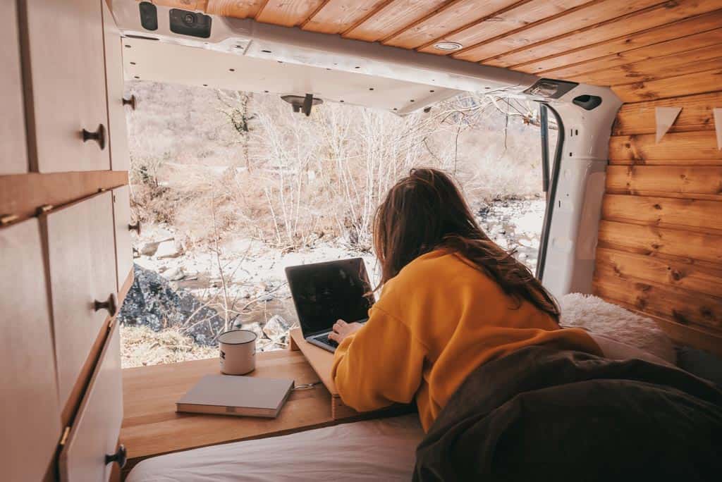 girl with laptop in campervan