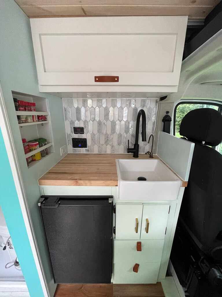 Kitchen with sink and fridge in a camper van