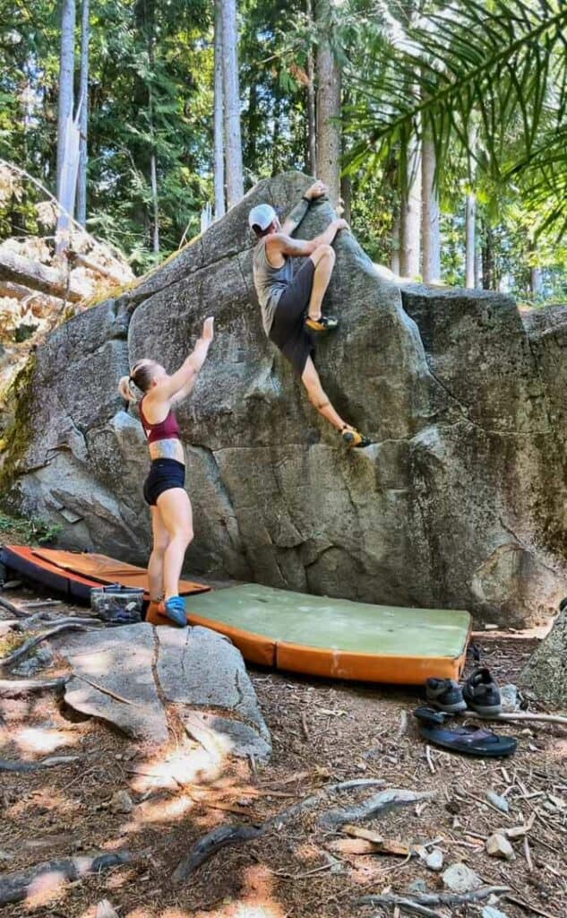two people climbing a rock