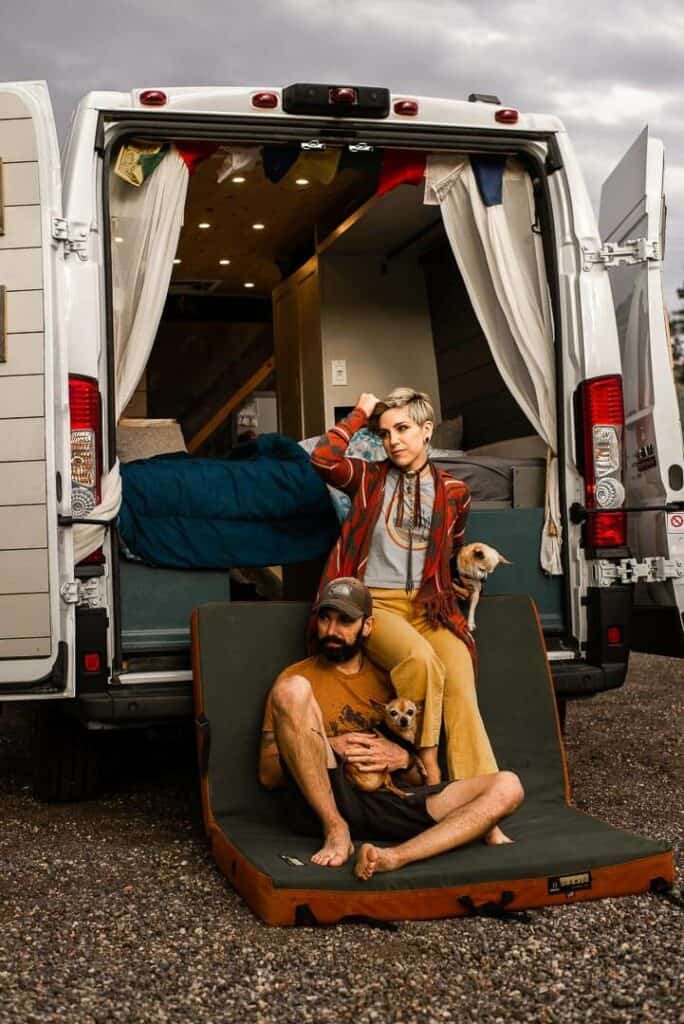 couple sitting in the back of a campervan