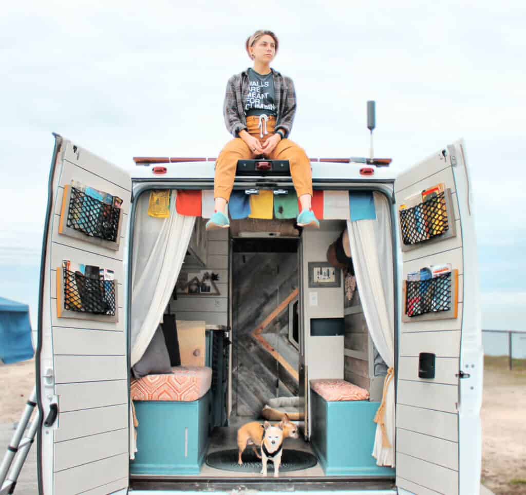 woman sitting on the roof of a campervan
