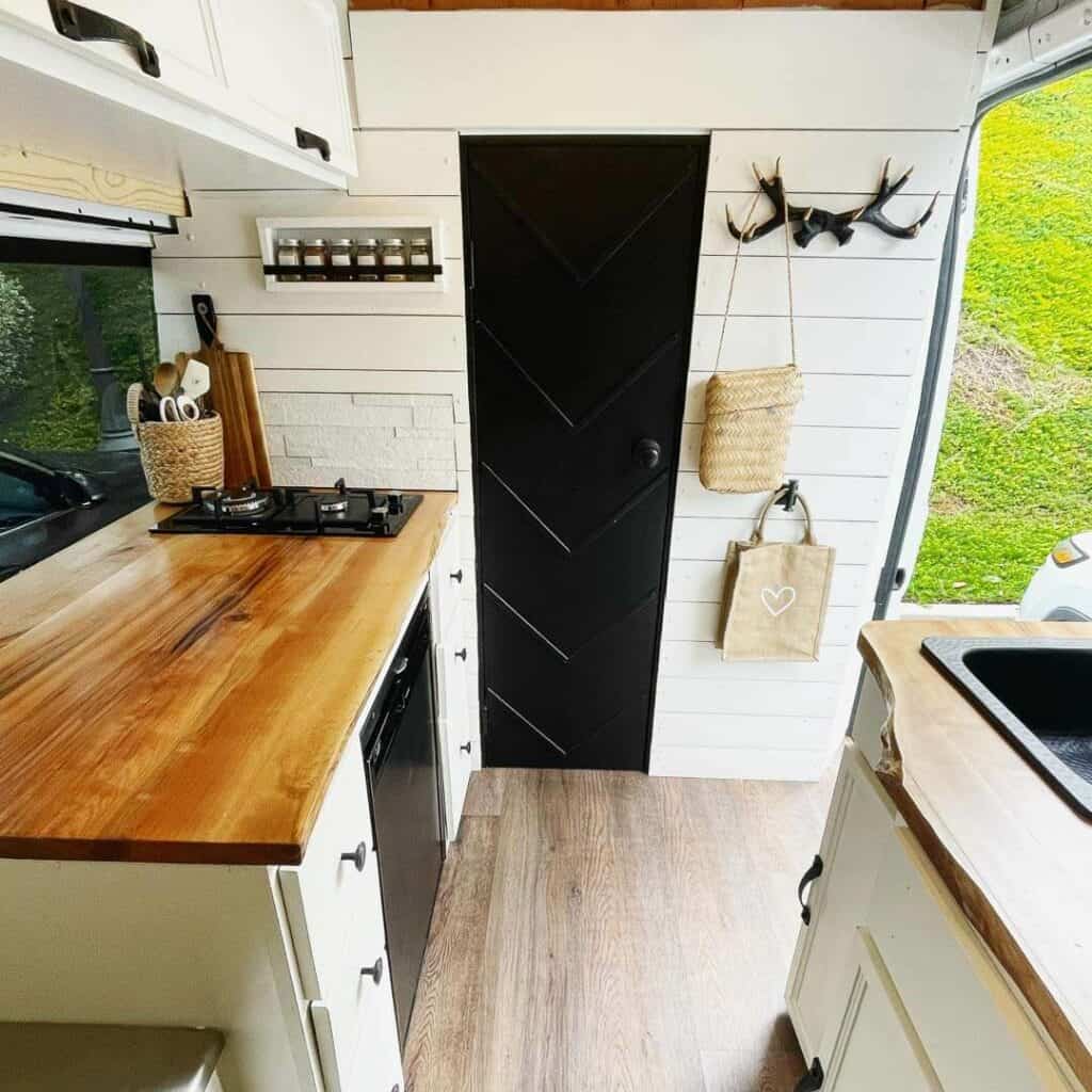 Campervan kitchen and bulkhead with door to cab area