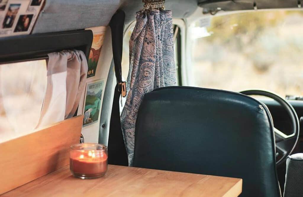 A lit candle sitting on a butcher block counter in a camper van